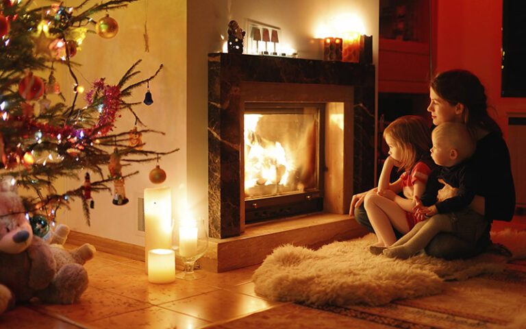 parent and children sitting near fireplace