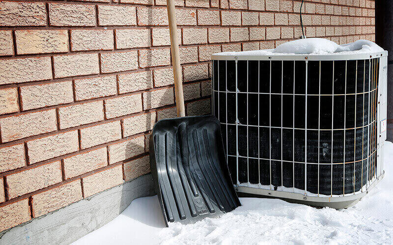 shovel next to heat pump, snow on ground