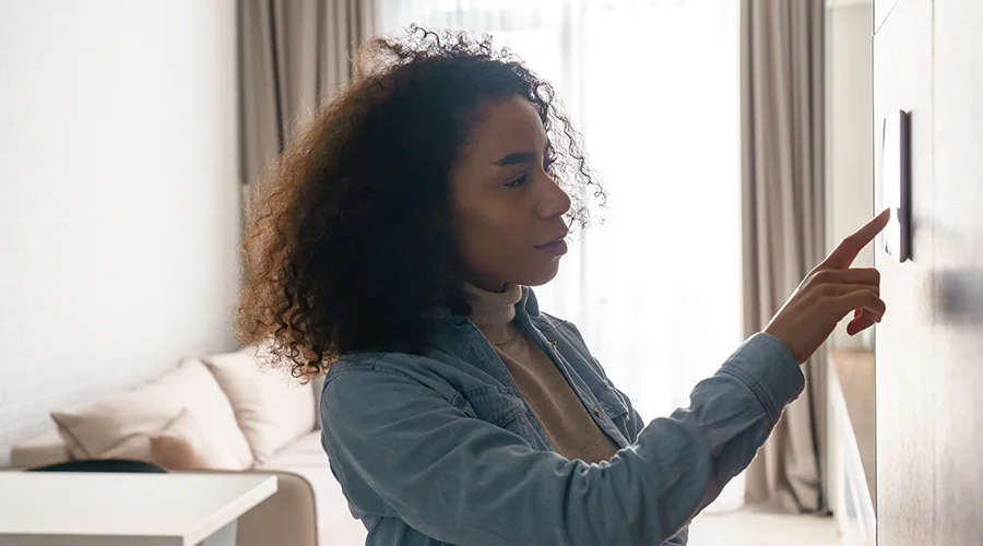 woman adjusting thermostat